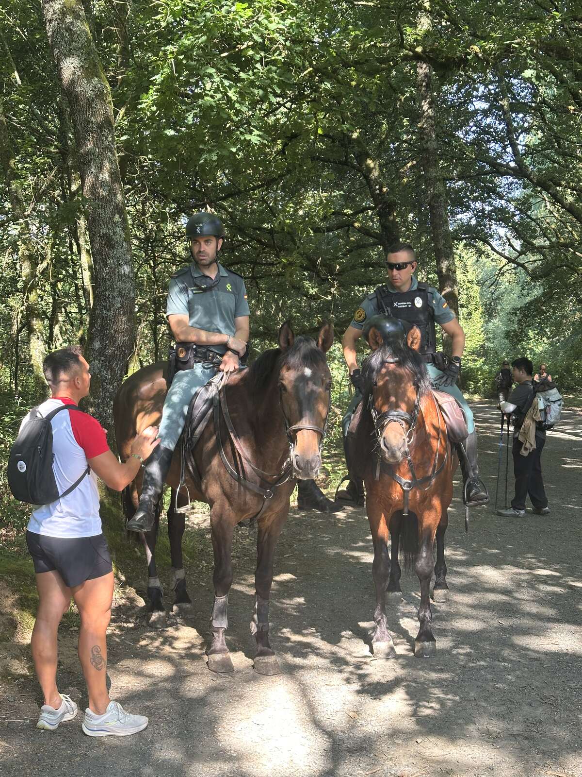 騎馬的 Guardia Civil，正在和一位朝聖者說話。