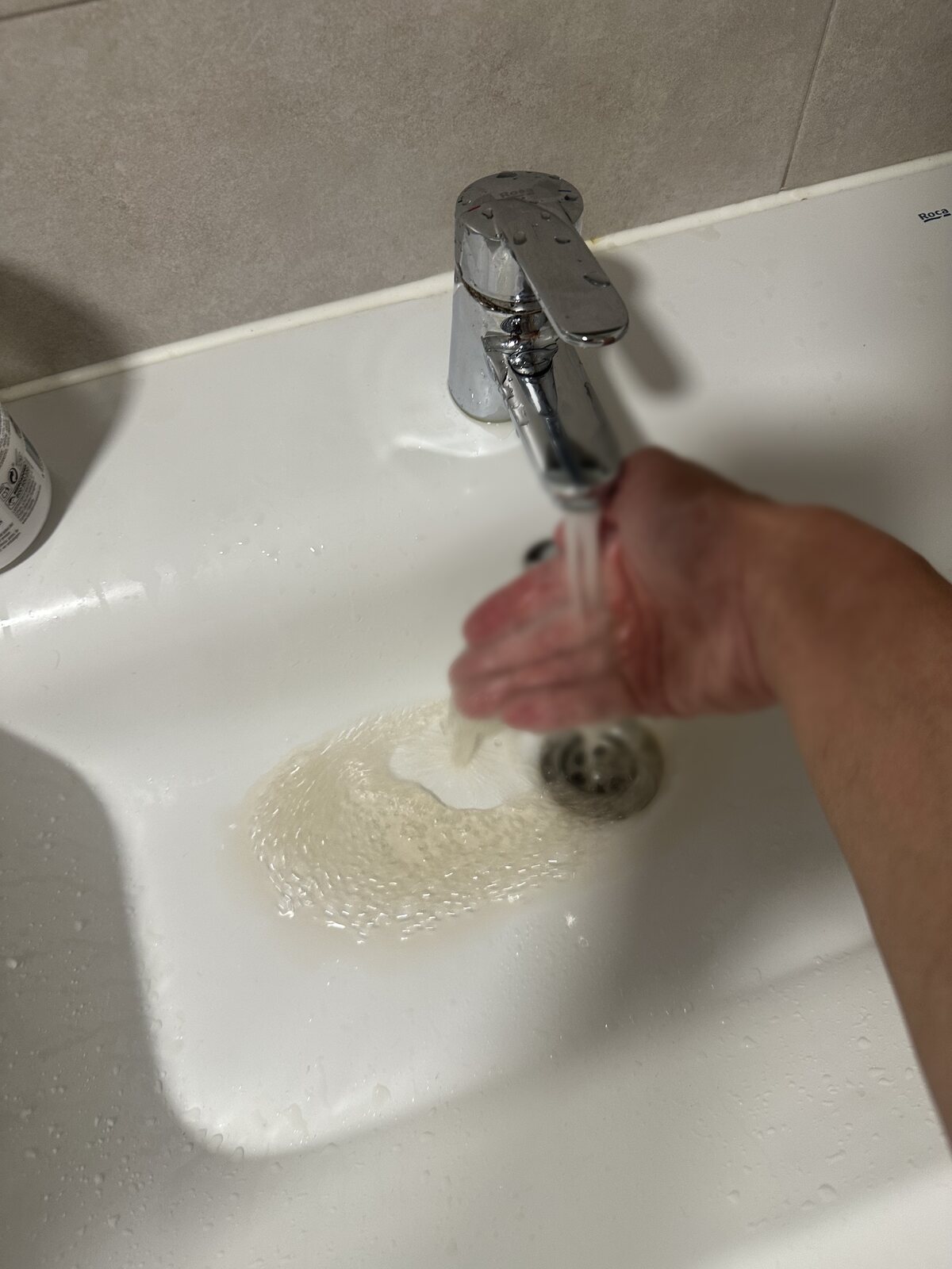 水龍頭流出來的水（手部已模糊處理）