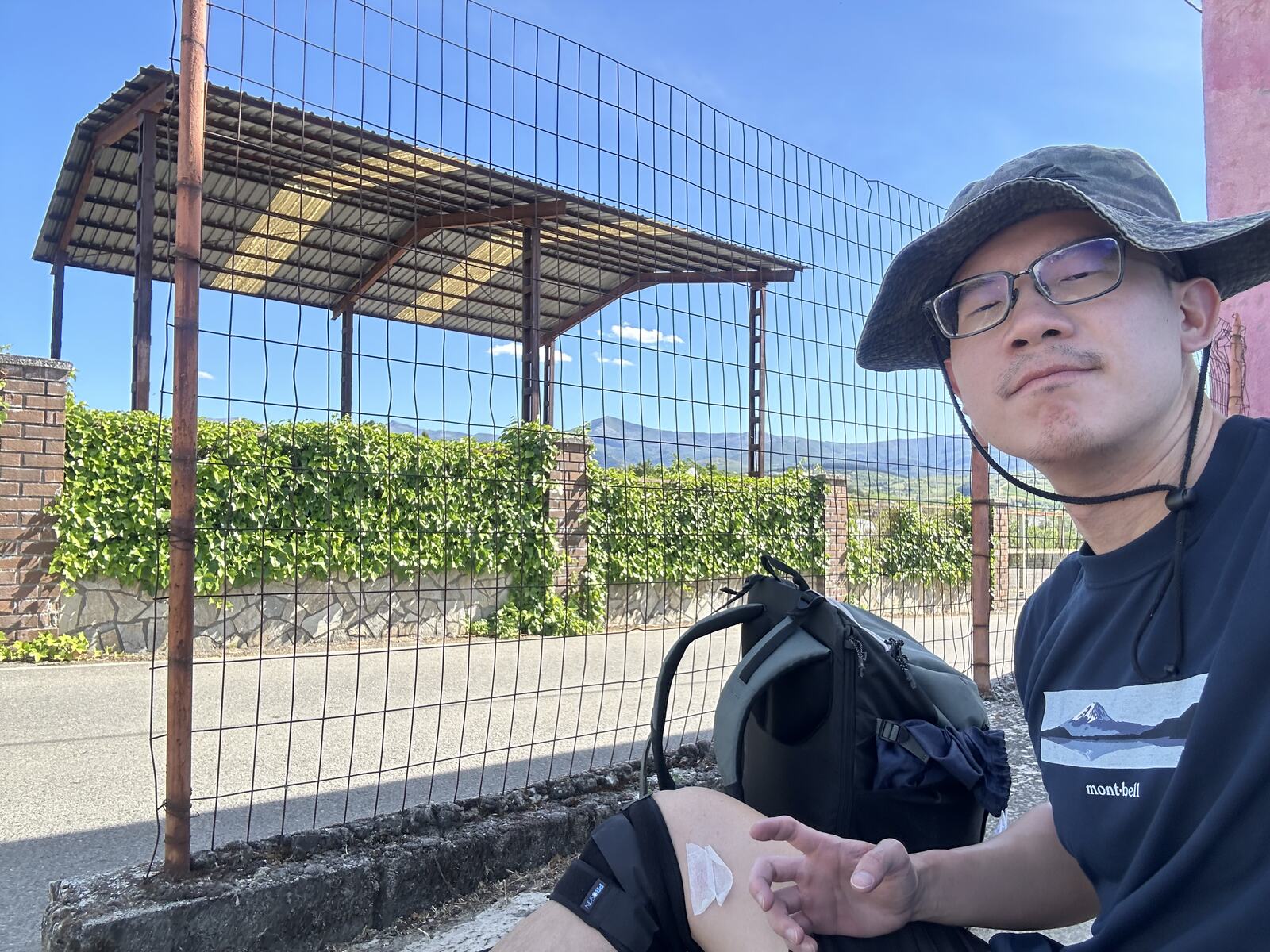 放下背包、脫掉鞋子，坐在別人家車庫前面透氣。水上的膠帶是我發現護膝會磨大腿貼的